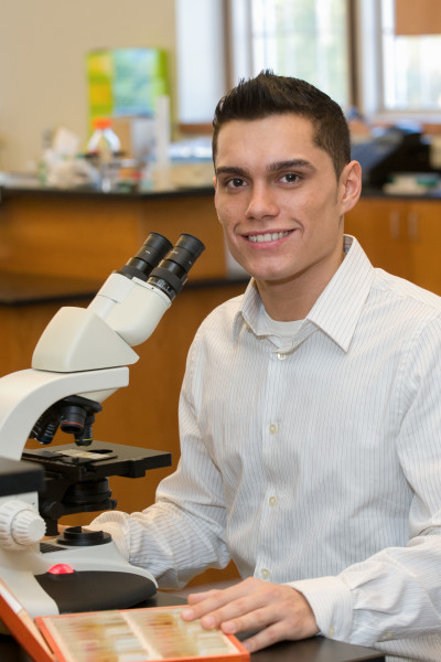 Ben Asen Editorial Photo: College of Mount Saint Vincent science student working on an experiment with microscope