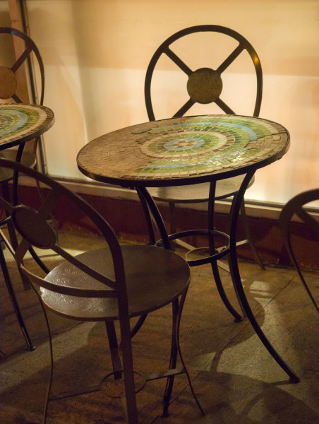 Ben Asen Personal Work Photo: Color photo of cafe chairs with mosaic top table at night.