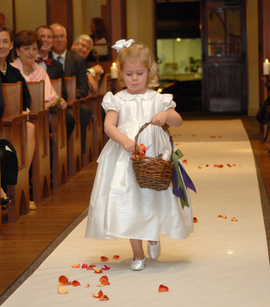 Ben Asen Celebrations Photo: Flower girl at wedding in a church throwing flower petals down the aisle