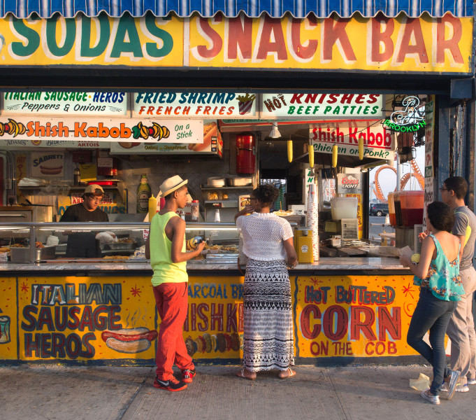 Ben Asen Personal Work Photo: Color photo of snack bar in Coney Island, Broolyn, New York with man with brimmed straw hat and 3 other people.