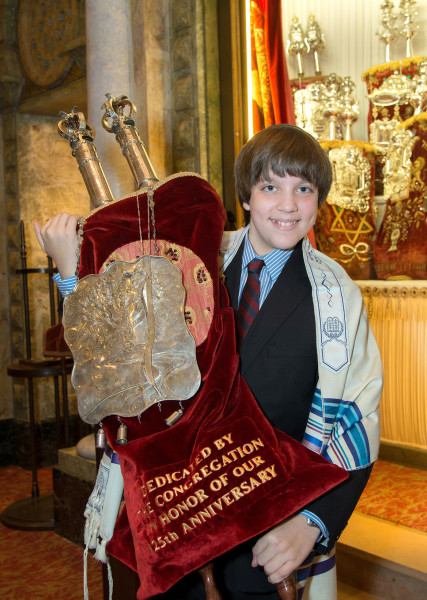Ben Asen Celebration Photo: Bar Mitzvah boy holding the Torah in a synagogue