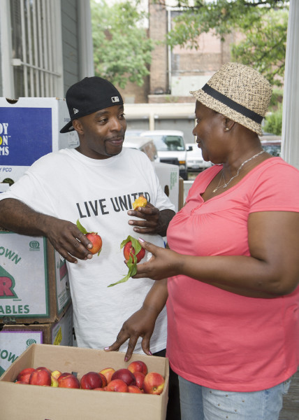 Ben Asen Editorial Photo: Man and woman working at a food distribution event for United Way of NYC in Brooklyn New York