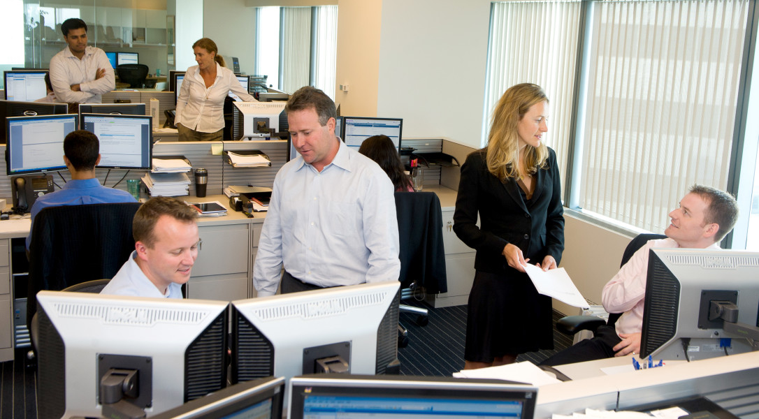 Ben Asen Editorial Photo: Office staff conversing about work in a financial office with computers