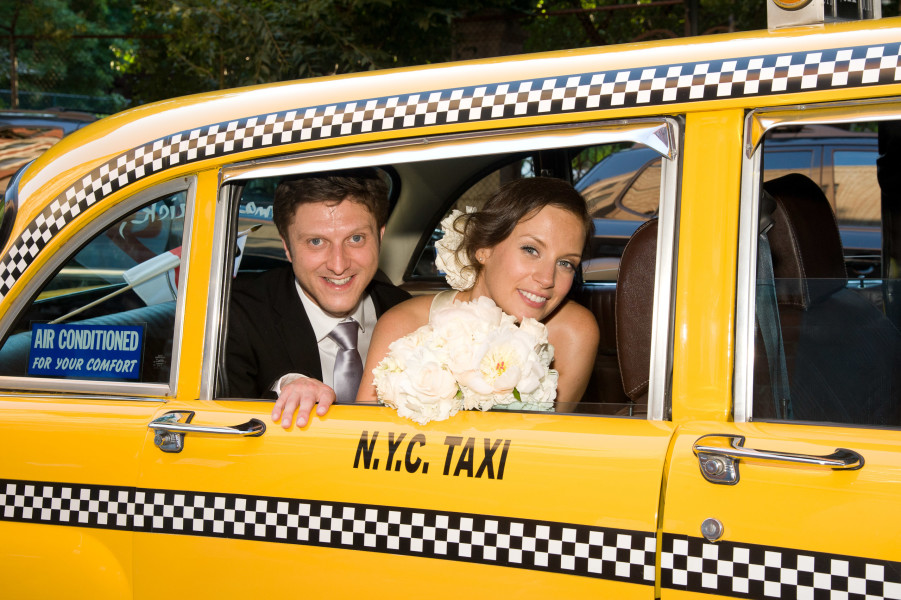 Ben Asen Celebrations Photo: Color photo of bride and groom looking out the window of a New York City taxi